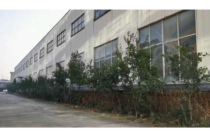Front-exterior-view-of-the-modern-industrial-facility,-specializing-in-agricultural-machinery-parts.
