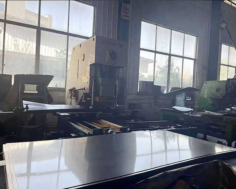 Custom die stamping precise hole patterns into a screen using a high-tonnage press at AGRO-GREENGO.