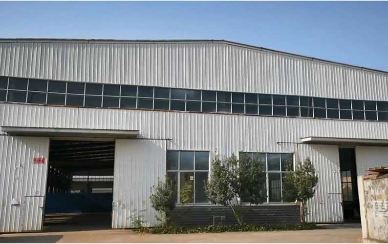 Front-exterior-view-of-the-modern-industrial-facility,-specializing-in-agricultural-machinery-parts.